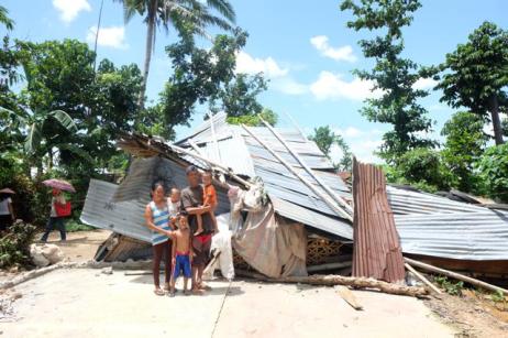 Rogie Alcazaren and family and the remnants of their home—in which they still reside.